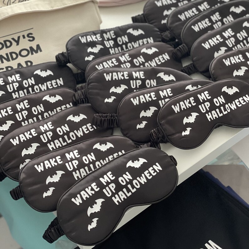 May include: A set of black sleep masks with white bats and the text "Wake Me Up On Halloween".