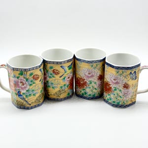 Puede incluir: Cuatro tazas de cerámica decorativas con diseños florales y de pájaros. Las tazas tienen un fondo amarillo con patrones florales rosas, rojos y azules. Cada taza tiene un asa blanca y un borde azul y blanco.