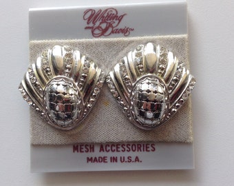 May include: Pair of silver-toned Whiting & Davis clip-on earrings. Each earring features a fan-shaped design with clear rhinestones and a textured, oval center. The earrings are on a gray backing with the text "MESH ACCESSORIES MADE IN U.S.A."