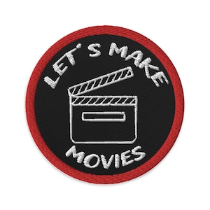 May include: A black and red embroidered patch with the text "Let's Make Movies" and a white outline of a clapperboard.