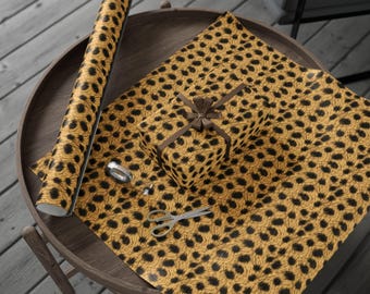 May include: A roll of leopard print wrapping paper with a small gift box wrapped in the same paper. The wrapping paper is on a wooden table with a pair of scissors and a roll of tape.