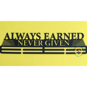 May include: Black metal medal display with the words "ALWAYS EARNED NEVER GIVEN". The display has three horizontal bars for hanging medals and a logo in the bottom right corner.