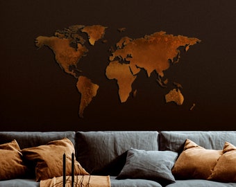May include: A dark blue sofa with brown throw pillows and a blanket. A wooden coffee table with a lamp, candles, books, and a vase with dried branches. A large metal world map hangs on the wall behind the sofa.