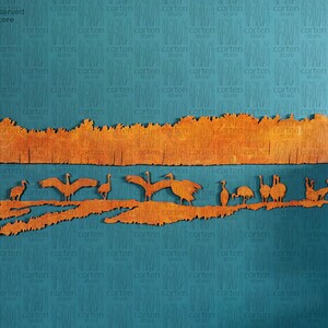 K&ouml;nnte beinhalten: Ein Wandbild aus Holz, das eine Reihe von V&ouml;geln darstellt, die &uuml;ber einem Feld mit hohem Gras fliegen. Die V&ouml;gel sind aus Holz ausgeschnitten und in einem warmen Orangeton bemalt. Das Gras ist ebenfalls aus Holz ausgeschnitten und in einem warmen Orangeton bemalt. Der Hintergrund ist in einem blaugr&uuml;nen Farbton gehalten.