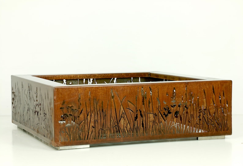 Pu&ograve; includere: Un vaso quadrato in metallo arrugginito con un design a taglio di erbe alte e fiori selvatici. Il vaso ha un design moderno e minimalista e sarebbe un'ottima aggiunta a qualsiasi giardino o patio.