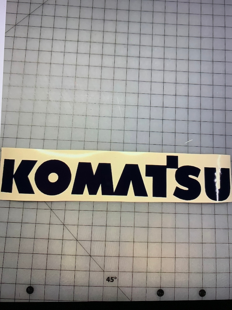 May include: Black vinyl decal with the word "KOMATSU" in bold, block letters.