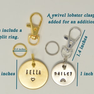 May include: Two round metal pet ID tags, one gold with the name "BELLA" and a heart, the other silver with the name "BAILEY" and a rainbow. Both tags are 1.25 inches in diameter and include a 0.6 inch split ring. A swivel lobster clasp can be added for an additional fee.