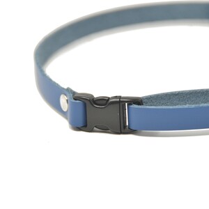 May include: A blue leather camera strap with a black plastic buckle.