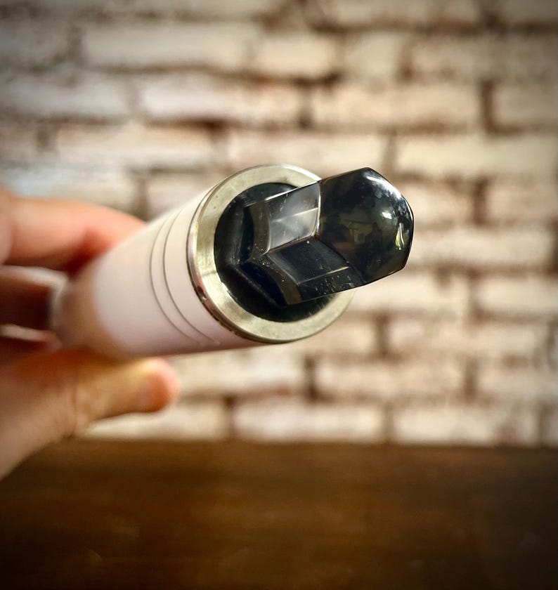 K&ouml;nnte beinhalten: Nahaufnahme einer wei&szlig;en und silbernen Steckschl&uuml;ssel-Garnitur mit einem schwarzen sechseckigen Kopf.