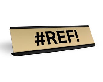 May include: A gold desk nameplate with a black border and the text "#REF!" in black.