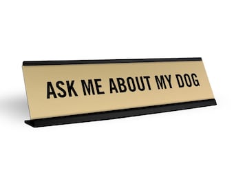 May include: Gold desk nameplate with black trim and the text "ASK ME ABOUT MY DOG" in black.