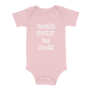 May include: A light pink baby onesie with short sleeves. The text "World's CUTEST Tax Credit" is printed in white, centered on the front. The onesie has a snap closure at the bottom.