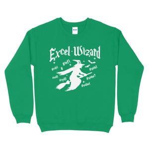 May include: Green sweatshirt with a white graphic of a witch flying on a broomstick with the text "Excel Wizard" and various Excel error messages like #REF!, #NUM!, #NAME?, #VALUE!, #N/A, and #SPILL!.