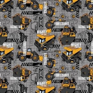 May include: A gray and yellow fabric with a repeating pattern of toy dump trucks. The trucks have the words "Mighty Dump Truck", "Frontloader", and "Tonka" on them. The fabric has a grid pattern.
