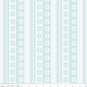 May include: A fabric with a repeating pattern of vertical stripes in light blue and white. The stripes feature snowflake and geometric designs. The fabric is marked with inches along the bottom edge. The text "Riley Blake Designs" is visible.