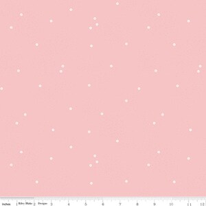May include: A pink fabric with a white polka dot pattern. The dots are randomly scattered across the fabric.