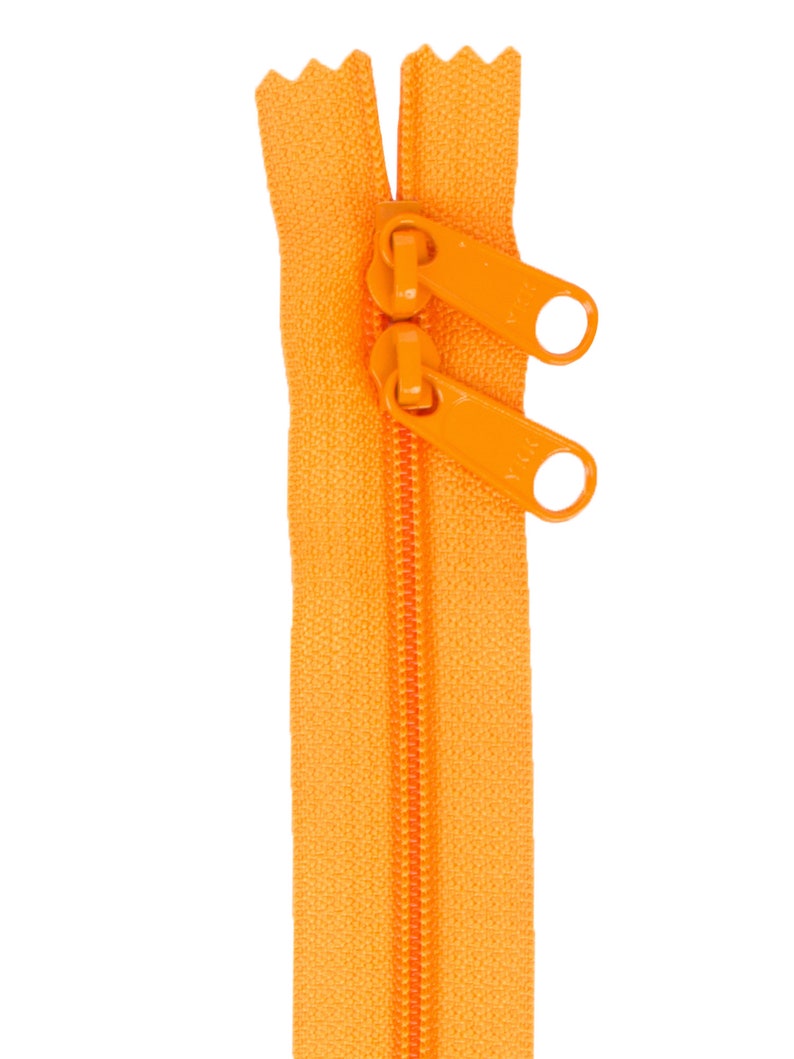 May include: A bright orange zipper with a metal slider and pull tabs. The zipper is open and the slider is in the middle of the zipper.