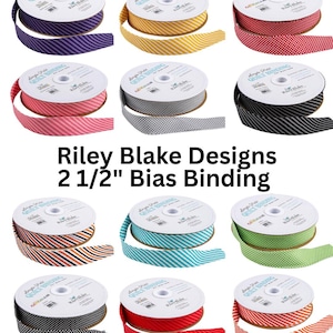 May include: A collection of Riley Blake Designs 2 1/2" bias binding rolls in various colors and patterns. The image shows spools of fabric with stripes, polka dots, and other designs. The text "Riley Blake Designs 2 1/2" Bias Binding" is visible.
