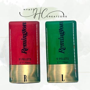 May include: Two rectangular, glossy resin pieces, one red and one green, resembling shotgun shells. Each features the "Remington" logo, "9 PELLETS", and "2 3/4 70mm" text. The red piece has an "R" and the green piece has an "L".