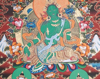 May include: A traditional Tibetan Buddhist thangka painting depicting a green deity, likely a manifestation of the Buddha of Compassion, surrounded by four smaller deities. The central figure is seated in a meditative posture, with a serene expression and adorned with elaborate jewelry. The painting is rich in detail, with intricate patterns and vibrant colors.