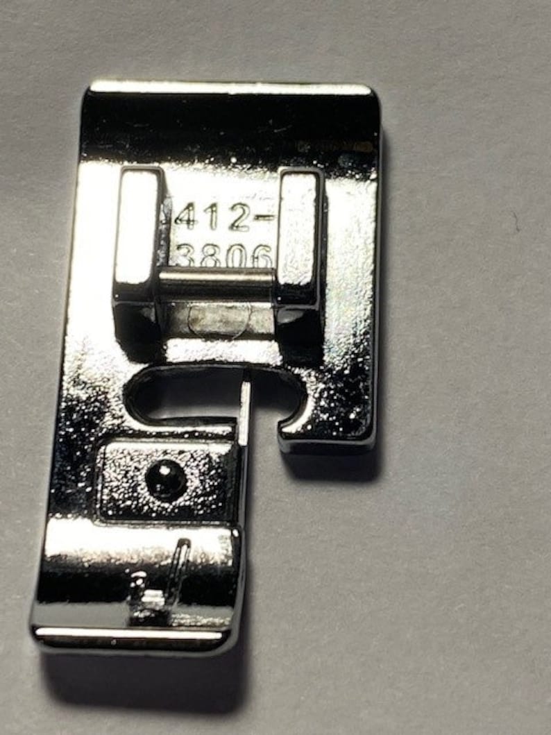 K&ouml;nnte beinhalten: Silbernes N&auml;hmaschinenfu&szlig; mit der Nummer 412-3806.