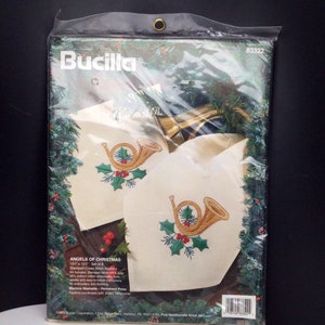 Puede incluir: Un juego de 8 servilletas de punto de cruz estampadas con un dise&ntilde;o de cuerno navide&ntilde;o dorado y verde. El kit incluye tela estampada, hilo de bordar, una aguja e instrucciones. Las servilletas son lavables a m&aacute;quina y de planchado permanente. El producto se llama "Angels of Christmas" y est&aacute; hecho por Bucilla.