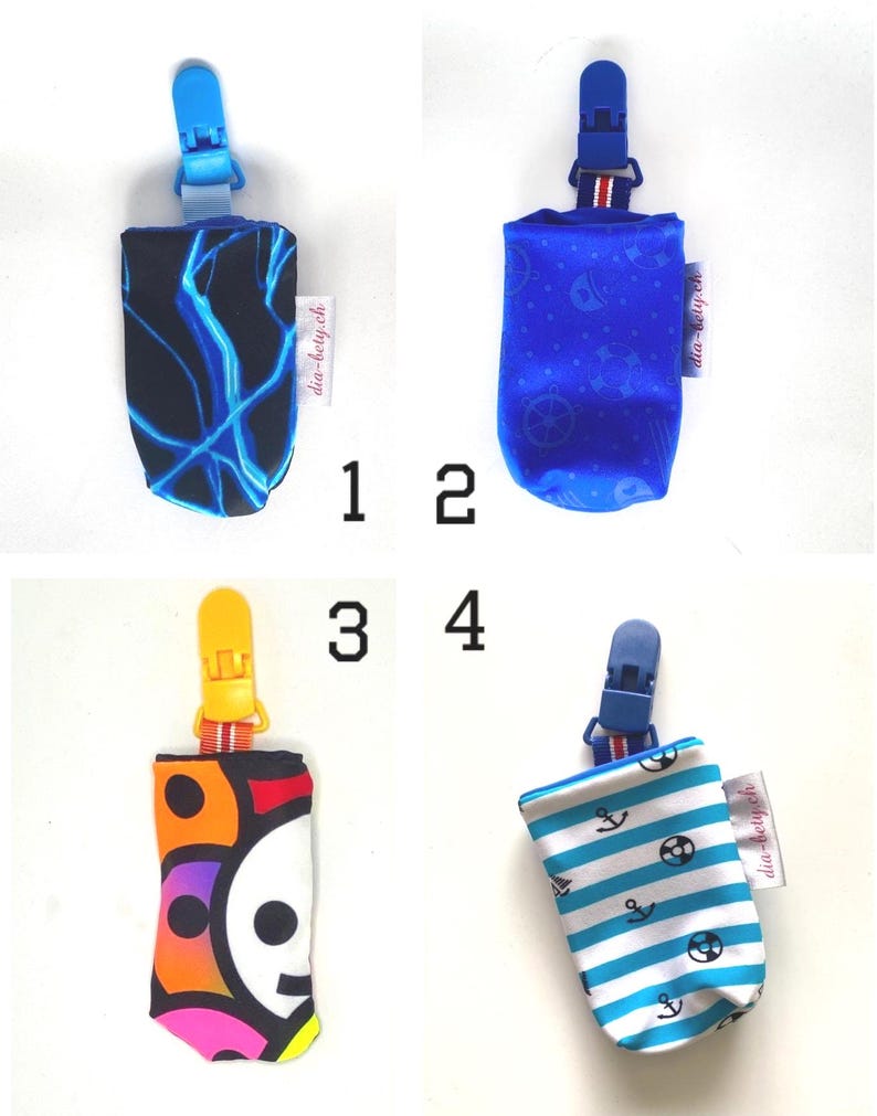 May include: Four pacifier clips with different fabric designs. The clips have a plastic clip at the top and a fabric pouch at the bottom. Designs include blue lightning, blue nautical, a skull, and blue and white stripes with anchors.