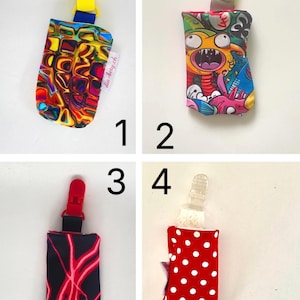 May include: Four baby bottle holders with clips. Designs include a colorful abstract pattern, a cartoon monster, a black pattern with red lightning, and a red polka dot pattern. Each holder has a different colored clip.