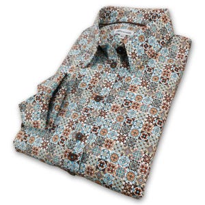 Pode incluir: Uma camisa branca de manga comprida com um padrão geométrico colorido. A camisa tem um colarinho abotoado e um fecho de botão castanho.