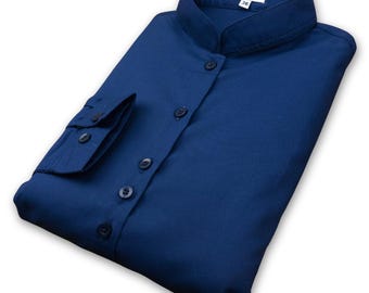 May include: A dark blue long-sleeved shirt with a mandarin collar and button closure. The shirt has a single pocket on the left sleeve.