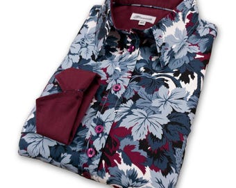 May include: A long-sleeved button-down shirt with a floral print in shades of blue, white, and burgundy. The shirt has a burgundy collar and cuffs.
