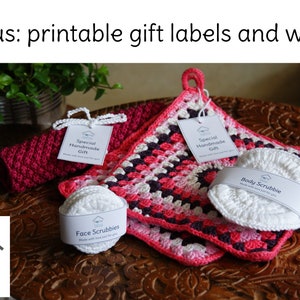 May include: A close-up of three crocheted gift items, including a pink and white crocheted pot holder, a pink crocheted washcloth, and a white crocheted body scrubbie. The items are on a wooden surface with a label that reads "Special Handmade Gift".