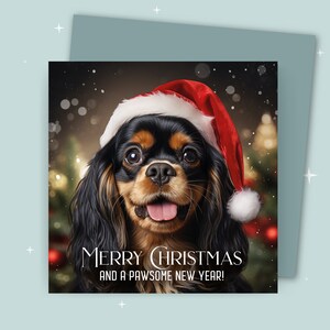 Weihnachtskarte / Merry Christmas and a Pawsome New Year / König Charles Cavalier trägt eine Weihnachtsmütze