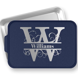 May include: A navy blue baking pan with a silver monogrammed design. The monogram features the letter "W" with the name "Williams" centered below the letter. The pan has a silver rim and a silver handle.