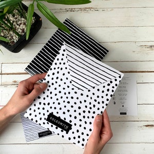 May include: Two black and white patterned envelopes with the text 'SOLESMITH' printed on the front. One envelope has a black and white polka dot pattern and the other has a black and white striped pattern.