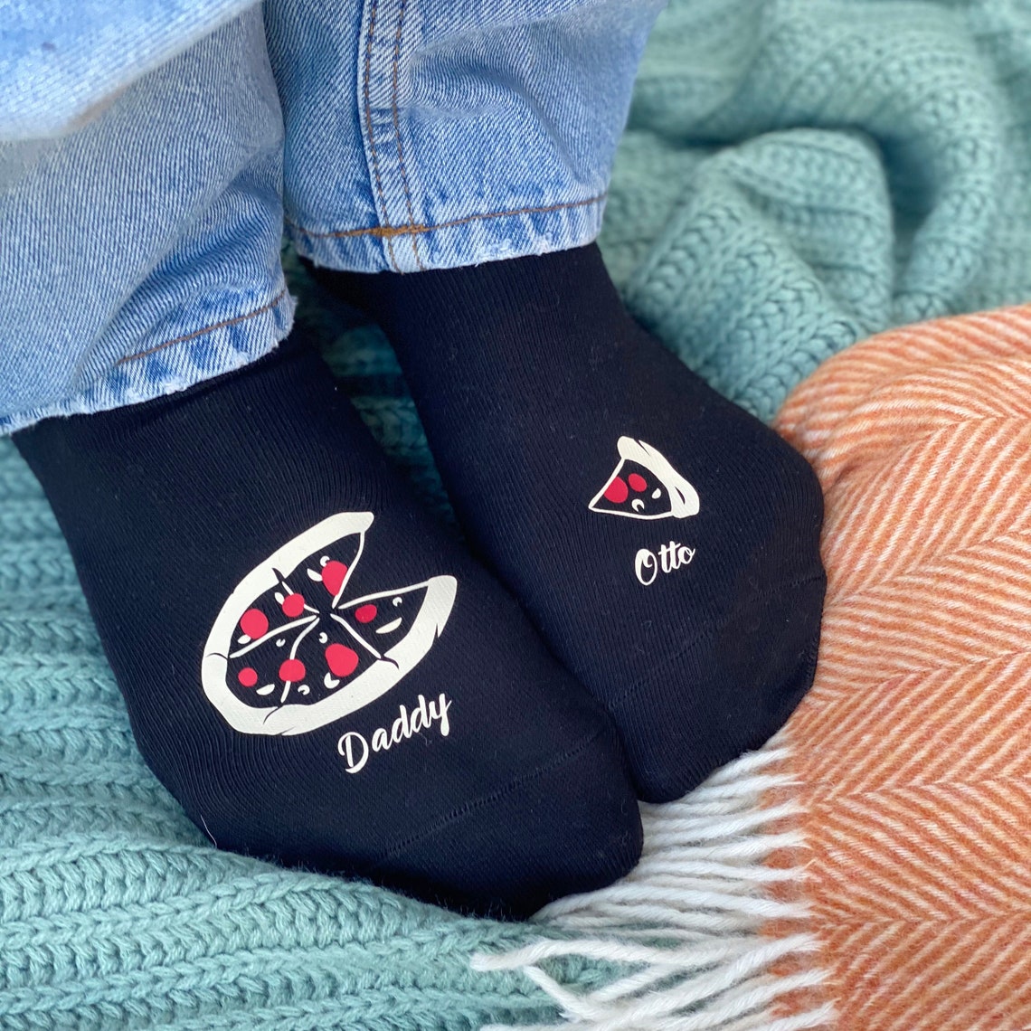 The socks feature an incomplete pizza on the one and a missing slice on the other. You also can add his name and your baby's name.