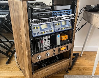 May include: A wooden rack with a variety of audio equipment, including a CD player, a mixer, and several audio processors. The rack is made of dark wood with a rustic finish.