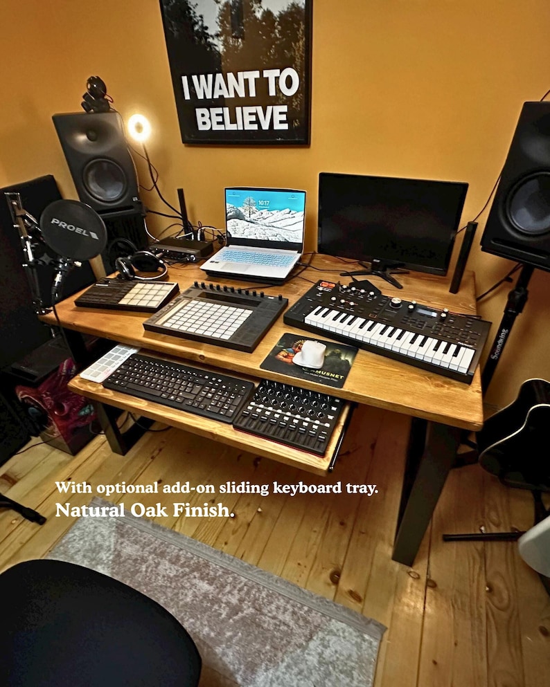 Solid wood desk in a music home studio, in a light colour finish and black steel legs. The desk features an optional add on sliding keyboard tray.