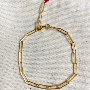 Pode incluir: Um bracelete de corrente dourada com fecho de lagosta. O bracelete &eacute; feito de uma s&eacute;rie de elos retangulares.