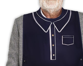 Puede incluir: Un babero azul marino con ribete blanco, que se asemeja a una camisa con cuello, con un bolsillo y botones.