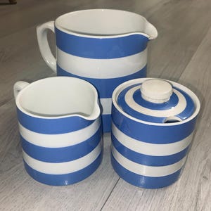 Pichets à lait en cornishware et un bidon de sucre