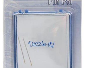 May include: A clear plastic Dazzle-it Pin Pal case with a blue border. The case contains two pins and the text "Dazzle-it" in blue script. The packaging includes the text "Magnetic case allows for easy storage and travel."