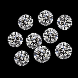 May include: Nine round-cut diamonds on a black backdrop. The clear diamonds sparkle, with many facets reflecting light. The arrangement is scattered, highlighting the brilliance of the gemstones. Each diamond is a perfect circle.