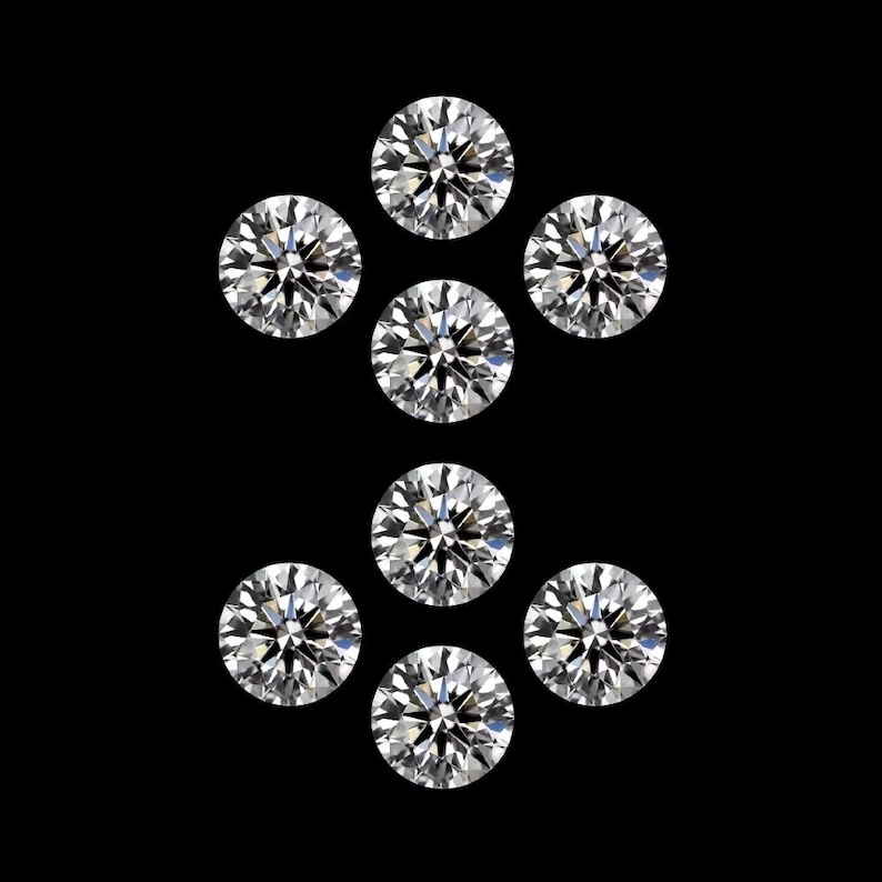 May include: Eight round-cut diamonds displayed against a black backdrop. The diamonds are clear and sparkling, reflecting light. The arrangement suggests a jewelry design or a collection of gemstones. Each diamond is perfectly round.