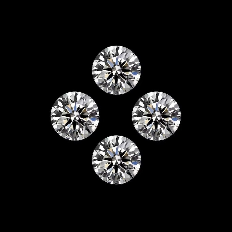 May include: Four round-cut diamonds set against a black backdrop. The gems are clear and sparkling, with numerous facets catching the light. The image showcases the brilliance and clarity of the gemstones, a classic jewellery design.