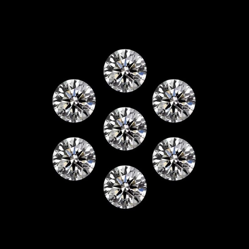 May include: Seven round-cut diamonds arranged in a circular pattern against a black backdrop. The diamonds are clear and sparkling, reflecting light. The image showcases the brilliance and facets of the gemstones.