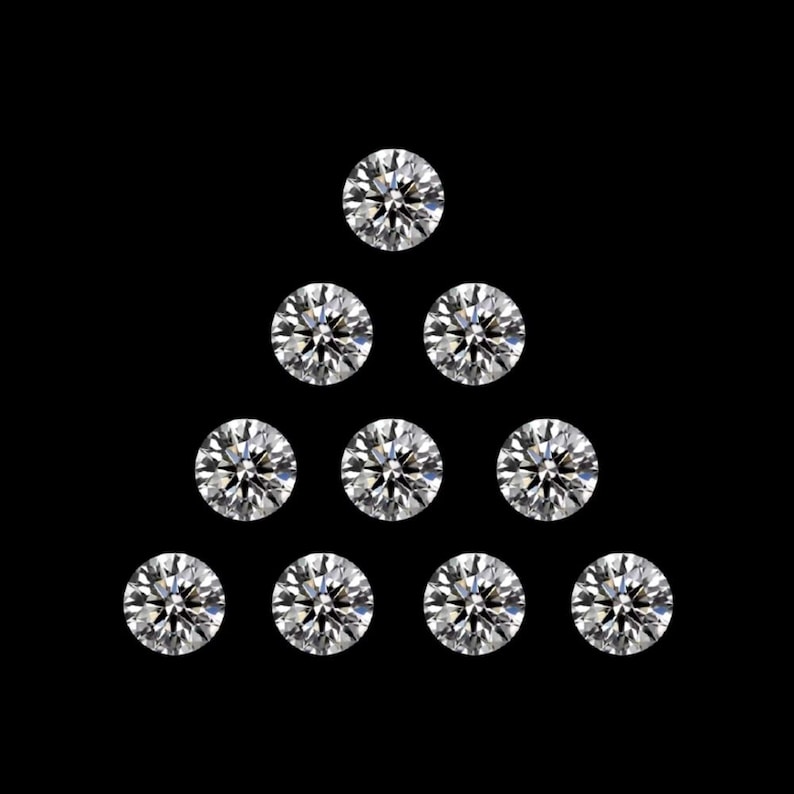 May include: Ten round-cut diamonds arranged in a triangular pattern against a black backdrop. The diamonds are clear and sparkling, reflecting light. The arrangement suggests a jewelry design or a display of gemstones.