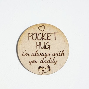 May include: A round wooden token with the text "Pocket Hug I'm always with you daddy" and a small heart and footprint design.