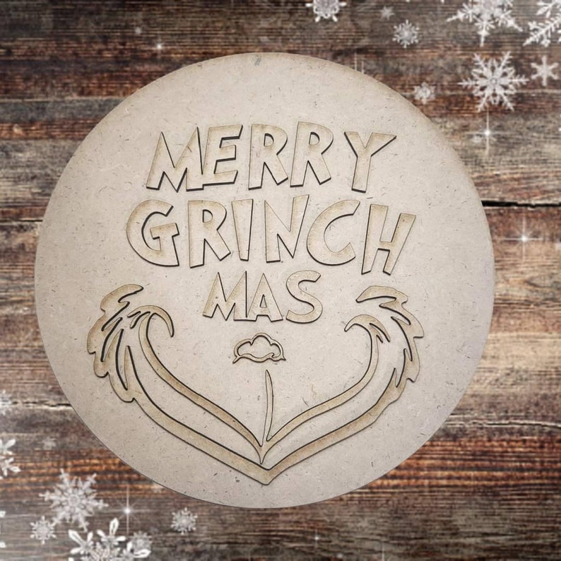 May include: A round wooden sign with the text "Merry Grinch Mas" in a whimsical font. The sign features a stylized heart shape with two palm tree-like designs on either side.