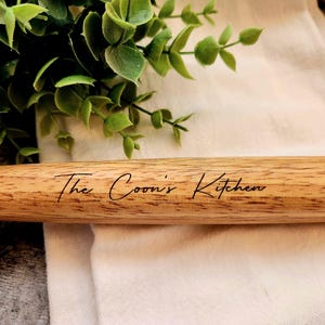 May include: A wooden rolling pin with the text "The Coon's Kitchen" engraved on it.